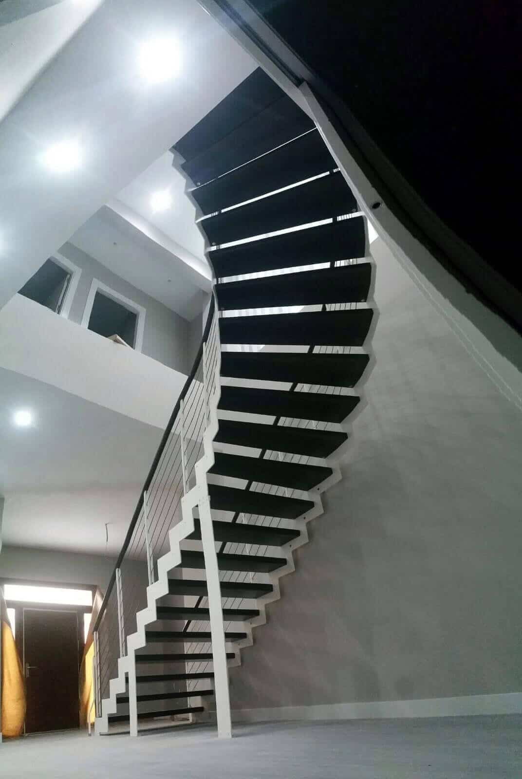 Escalera en curva de madera y metal de Enesca
