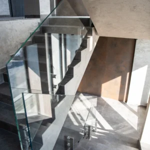 Barandilla T11 de cristal con montantes en una escalera interior